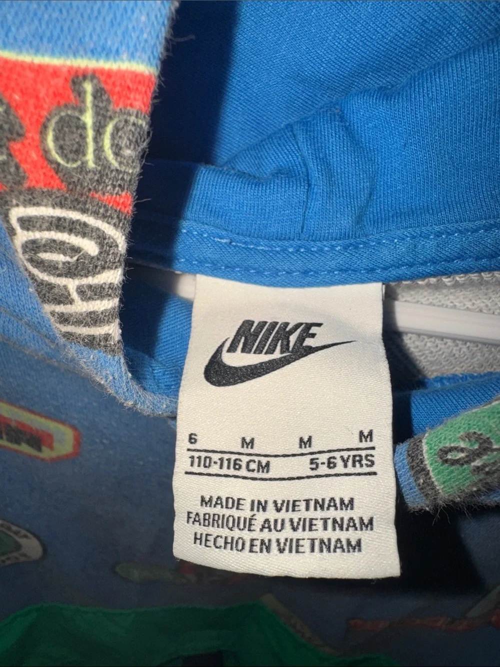 Nike Kids Blue Hoodie with Green Front Pocket and Graphic Badges